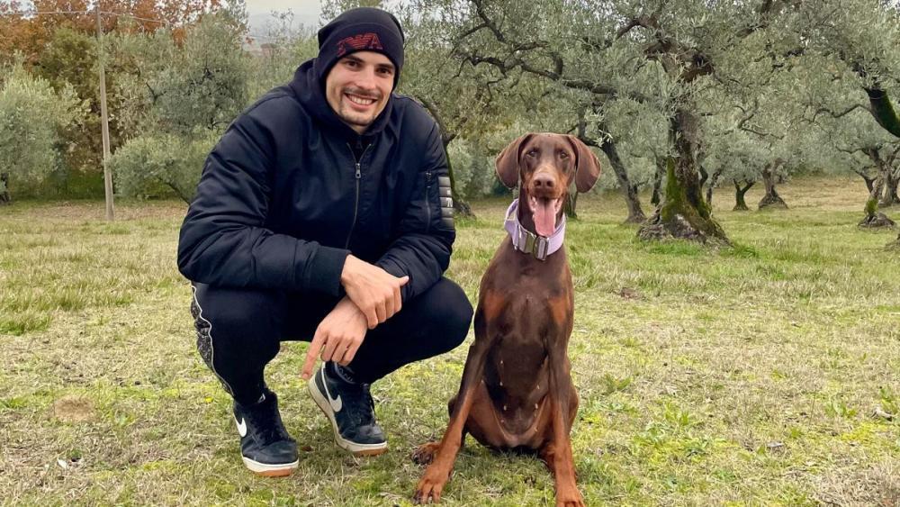 Simone Giannelli mit seiner Hündin Lily im Olivenhain.