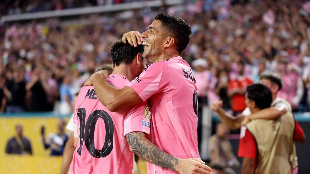 Lionel Messi celebrates with teammate Luis Suarez. © APA / MEGAN BRIGGS