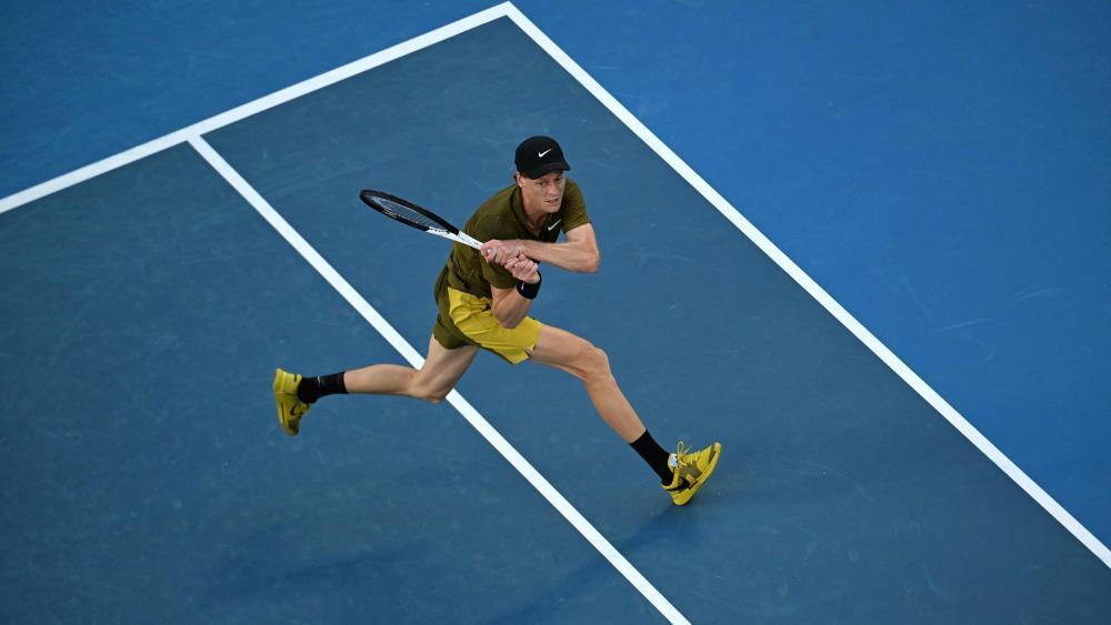 Jannik Sinner schlägt in Melbourne auf. © APA/afp / PAUL CROCK
