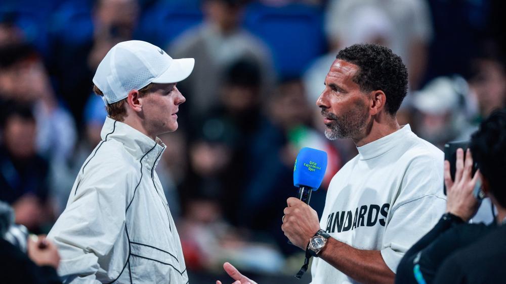 Jannik Sinner (links) wurde nach der ersten Runde von Ex-Fußballer Rio Ferdinand (rechts) interviewt. © APA/afp / KARIM JAAFAR