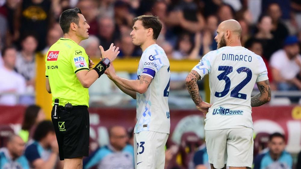 Inters Nicola Barella (Mitte) und Federico Dimarco (rechts) reden mit dem Schiri. © AFP / MARCO BERTORELLO