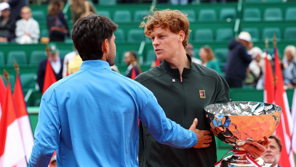 Jannik Sinner und Carlos Alcaraz herzen sich. © APA/afp / VALERY HACHE