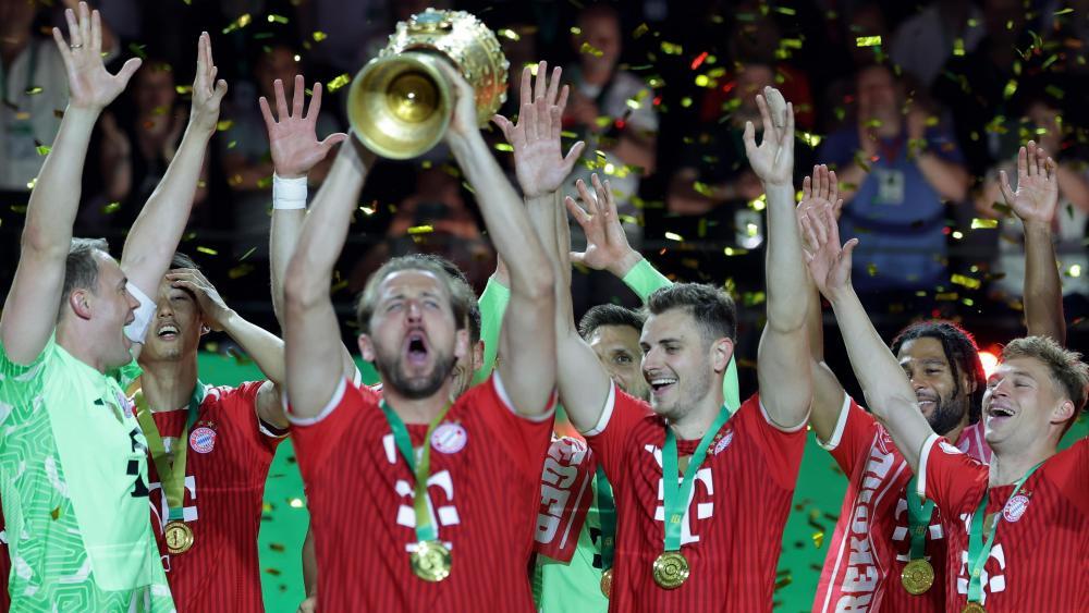Harry Kane (Dritter von links) streckt den DFB-Pokal in die Höhe. © ANSA / CHRISTOPHER NEUNDORF