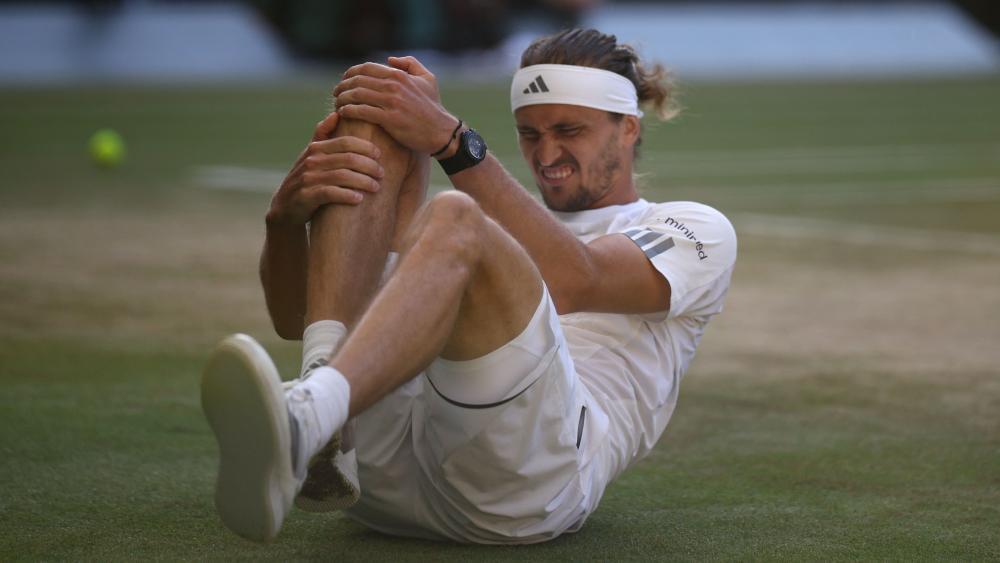 Alexander Zverev hält sich das rechte Knie. © APA/afp / HENRY NICHOLLS