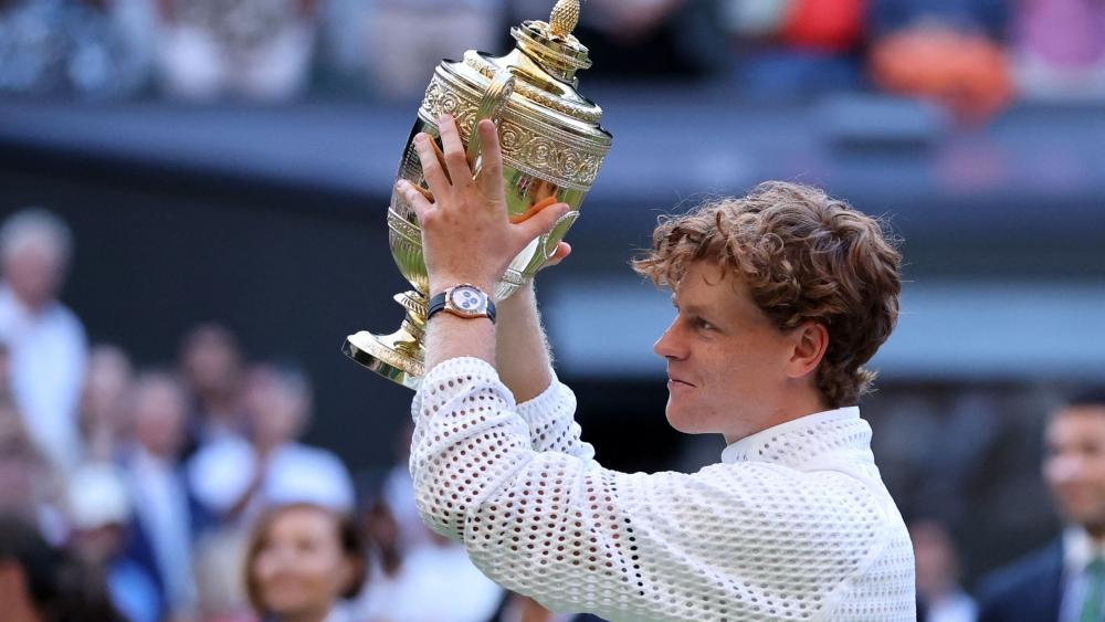 Jannik Sinner stemmt die Wimbledon-Trophäe in die Höhe. © APA/afp / HENRY NICHOLLS