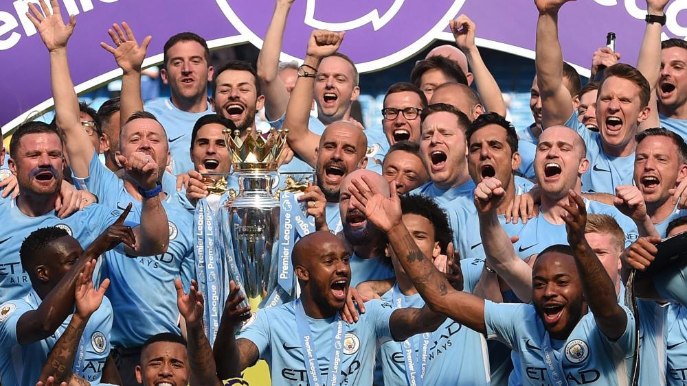 Über die Ära von Pep Guardiola (hält Trophäe) und Co. bei Manchester City legt sich ein dunkler Schatten. © APA/afp / OLI SCARFF