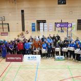 Gruppenfoto aller zehn teilnehmenden Mannschaften in der Kalterer Dreifach-Turnhalle. © M. Ferrario