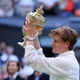 Jannik Sinner stemmt die Wimbledon-Trophäe in die Höhe. © APA/afp / HENRY NICHOLLS