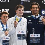 Thomas Ceccon (r.) mit der Bronzemedaille. Daneben: Hubert Kos (Mitte) und Apostolos Siskos. © APA/afp / JULIEN DE ROSA