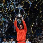 Carlos Alcaraz stemmt eine Trophäe in die Höhe. © APA/afp / RIE KIKUCHI
