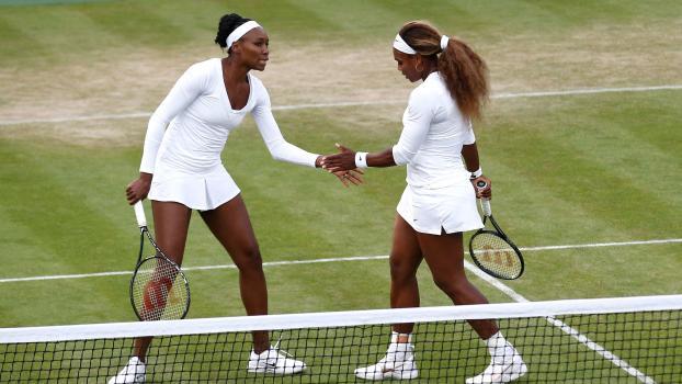 Zehn Jahre nach diesem Foto werden Venus und Serena Williams wieder gemeinsam in Wimbledon aufschlagen. © APA/afp / ANDREW COWIE
