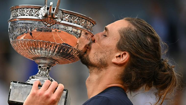 Alexander Zverev stemmt erstmals eine Grand-Slam-Trophäe in die Höhe. © APA/afp / JULIEN DE ROSA