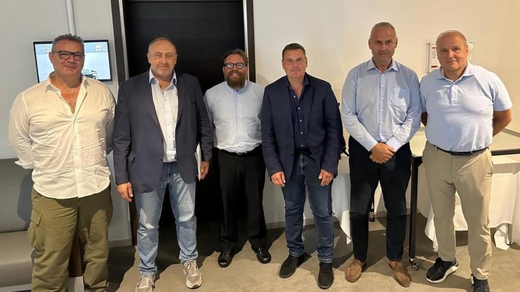 Stefan Zisser (3.v.l.), der Präsident des Südtiroler Landeseissport-Verbandes  mit den Präsidentschaftskandidaten Fabio Labia, Walter Andriolo (v.l.), Tommaso Teofoli (3.v.r.) und Andrea Gios (r.) sowie Thomas Rottensteiner (2.v.r.), der erneut für das Amt des Vizepräsidenten kandidiert.