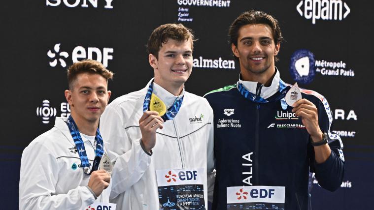 Thomas Ceccon (r.) mit der Bronzemedaille. Daneben: Hubert Kos (Mitte) und Apostolos Siskos. © APA/afp / JULIEN DE ROSA