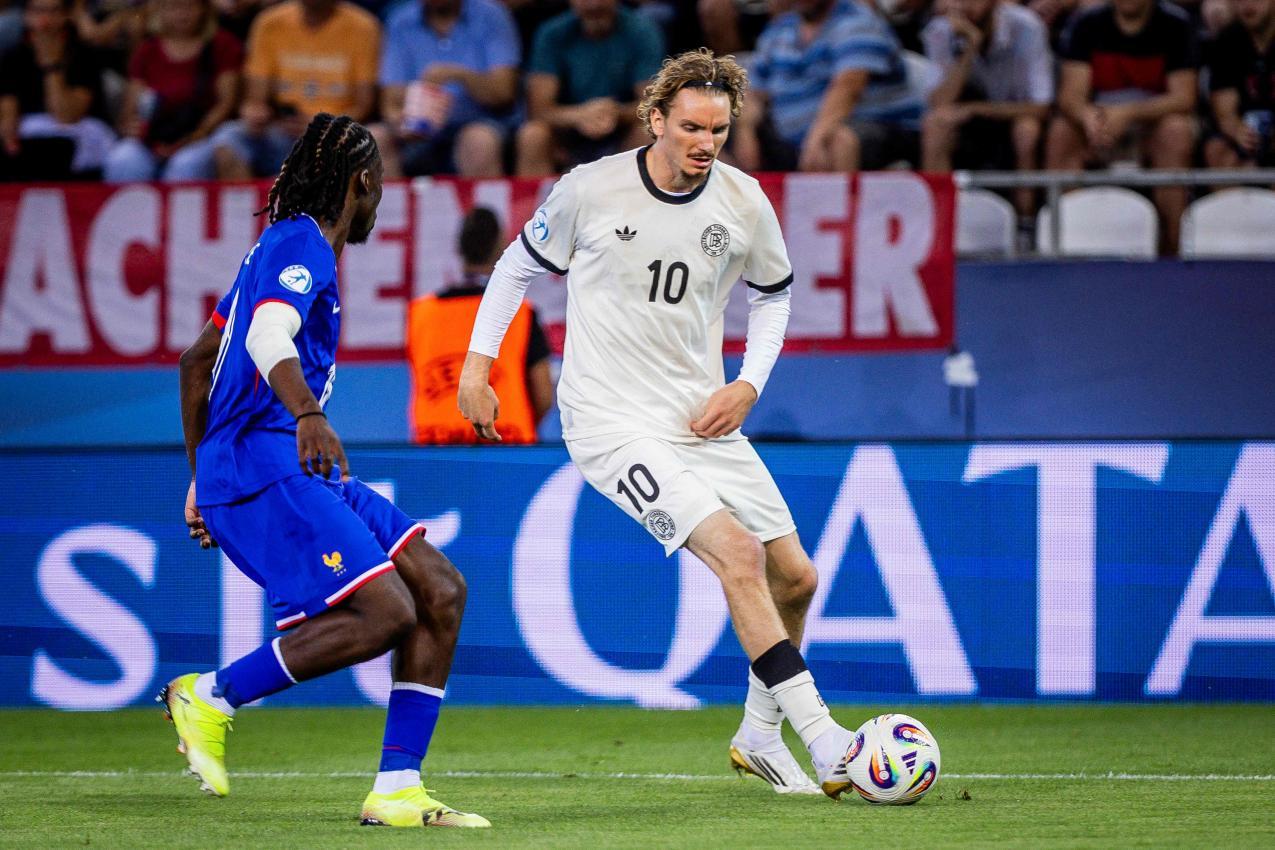 Nick Woltemade (am Ball gegen Frankreichs Ismael Doukoure) spielt eine überragende U21-EM. © APA/afp / BRANISLAV RACKO