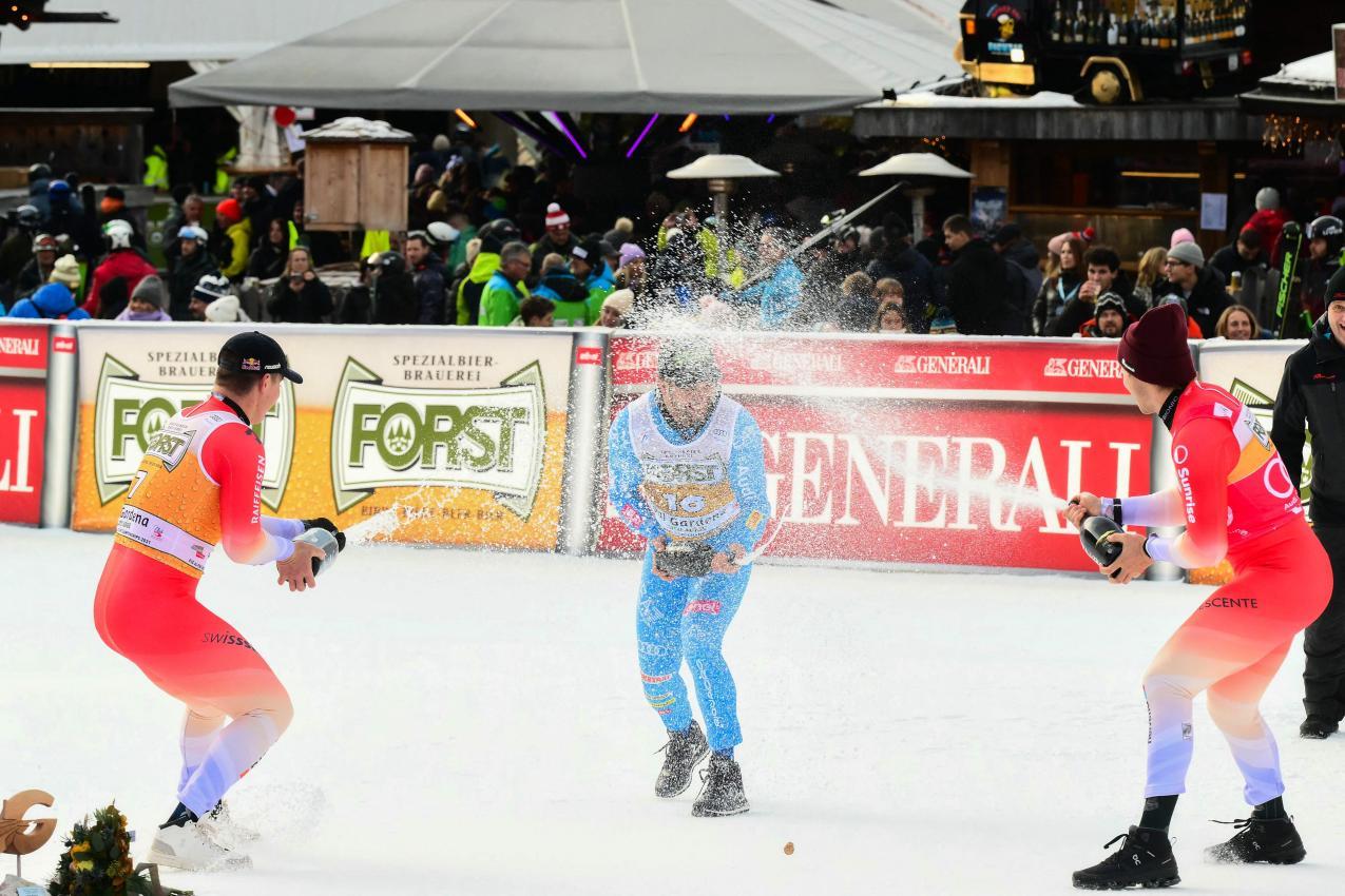 Die Podestmänner lassen es krachen, von links: Franjo von Allmen, Florian Schieder und Marco Odermatt. © APA/afp / STEFANO RELLANDINI