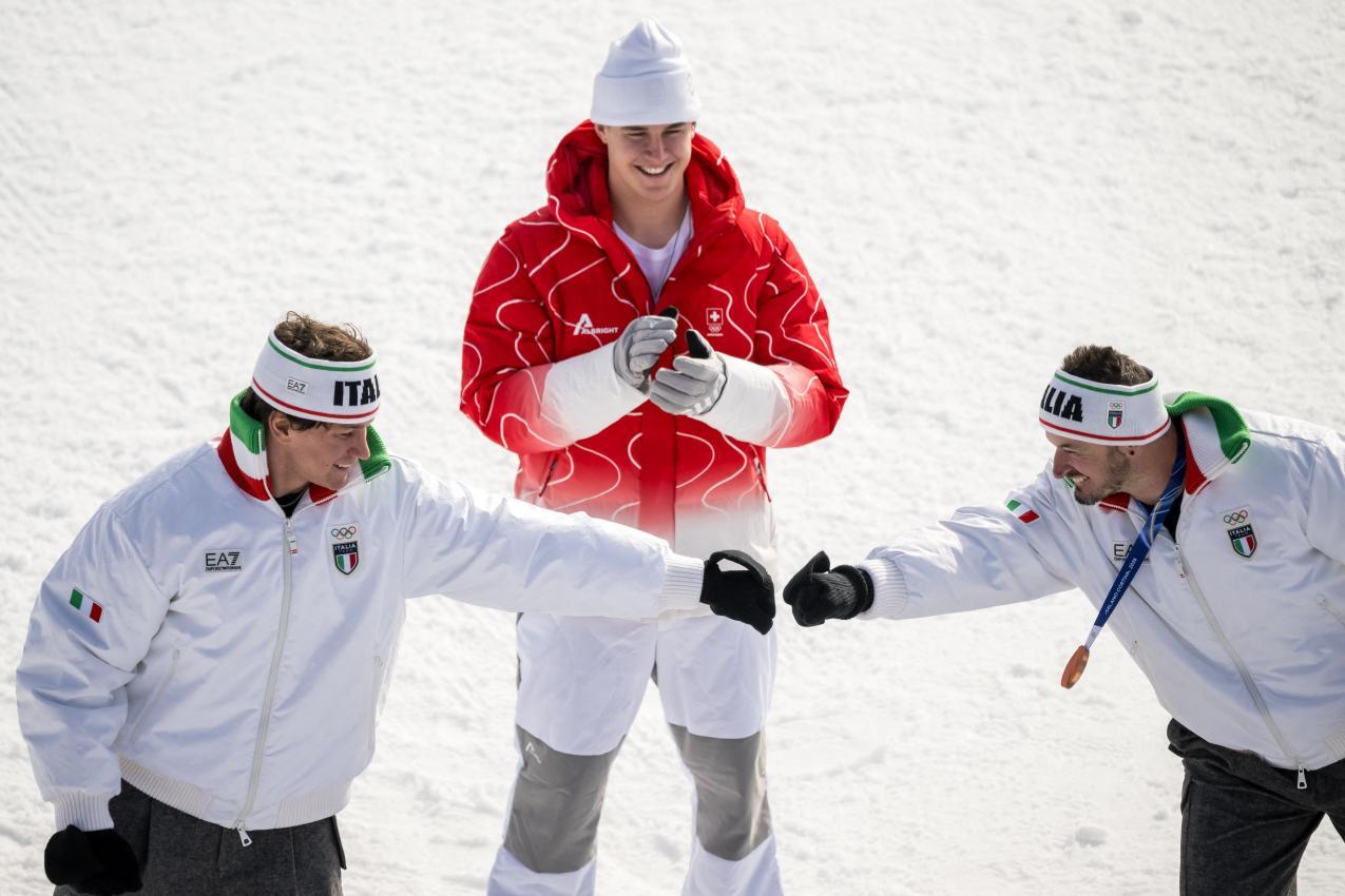 So strahlen Medaillengewinner: Paris (rechts) mit Franzoni (links) und von Allmen (hinten). © APA/afp / FABRICE COFFRINI