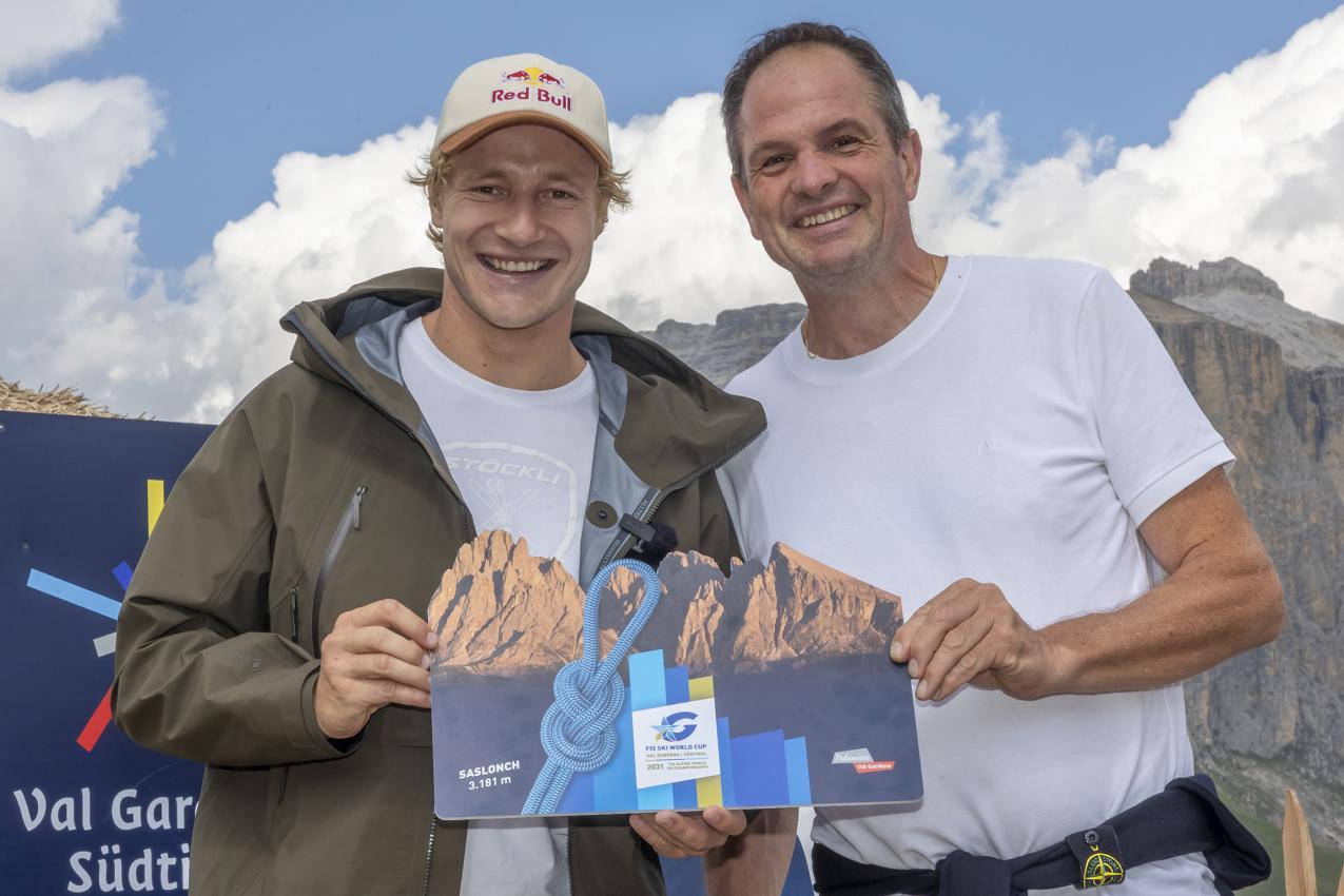 Ambros Hofer (rechts) vom Tourismusverein St. Ulrich übergab Marco Odermatt einen Gutschein für eine geführte Langkofel-Besteigung, die er gleich am Freitag eingelöst hat. © Saslong Classic Club