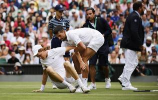 Novak Djokovic half Jannik Sinner nach einem schweren Sturz auf die Beine. © ANSA / TOLGA AKMEN